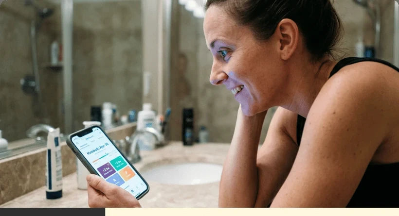 Woman reviewing health tracking results on her phone in the bathroom